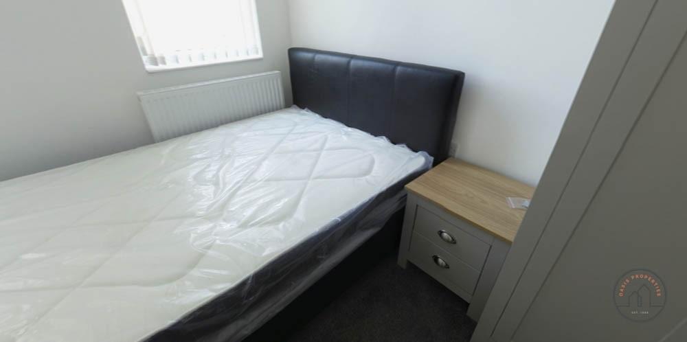 Bright, simply furnished bedroom with a comfort...