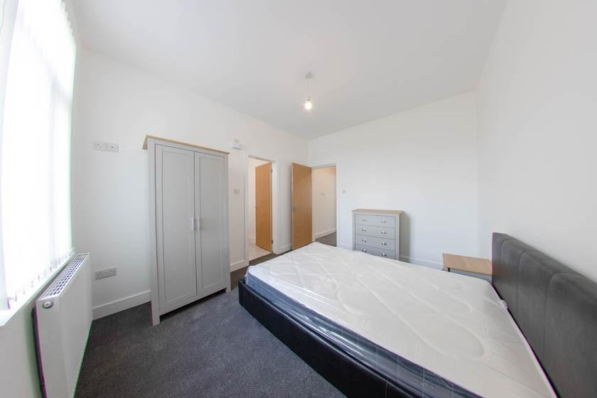 Bright, neutral double bedroom with a large win...