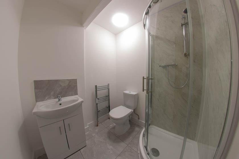 Modern bathroom with a corner glass shower encl...