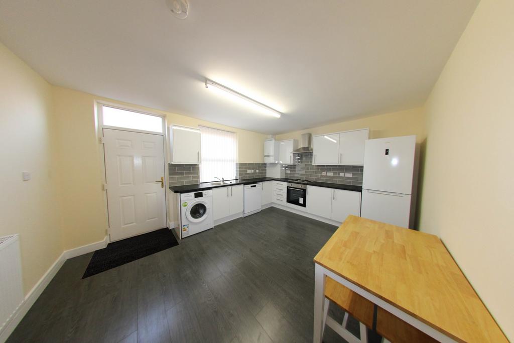 Bright, modern open-plan kitchen with white cab...