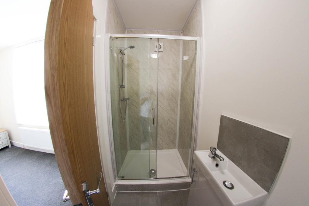 Bright modern bathroom with a corner glass show...