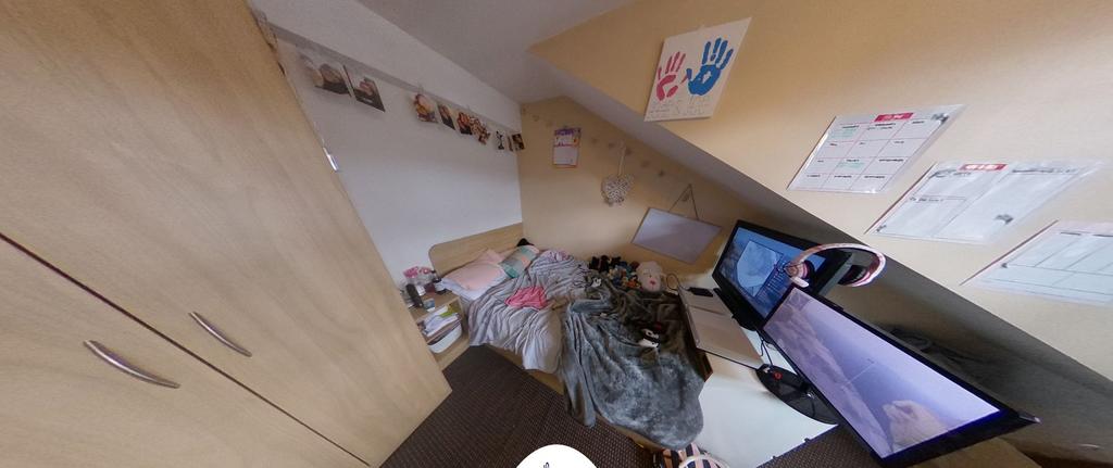 Compact attic-style bedroom with sloped ceiling...