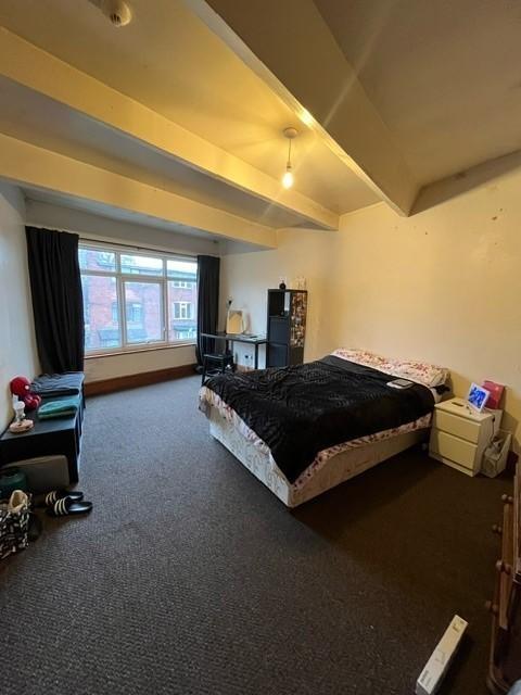 Spacious bedroom with a large window, double be...