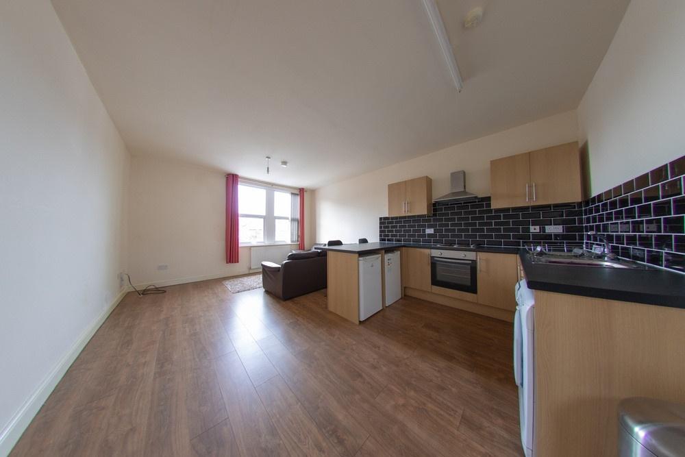 Open-plan living area with a fitted kitchenette...
