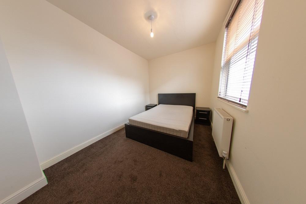 Neat double bedroom with a large bed, neutral d...