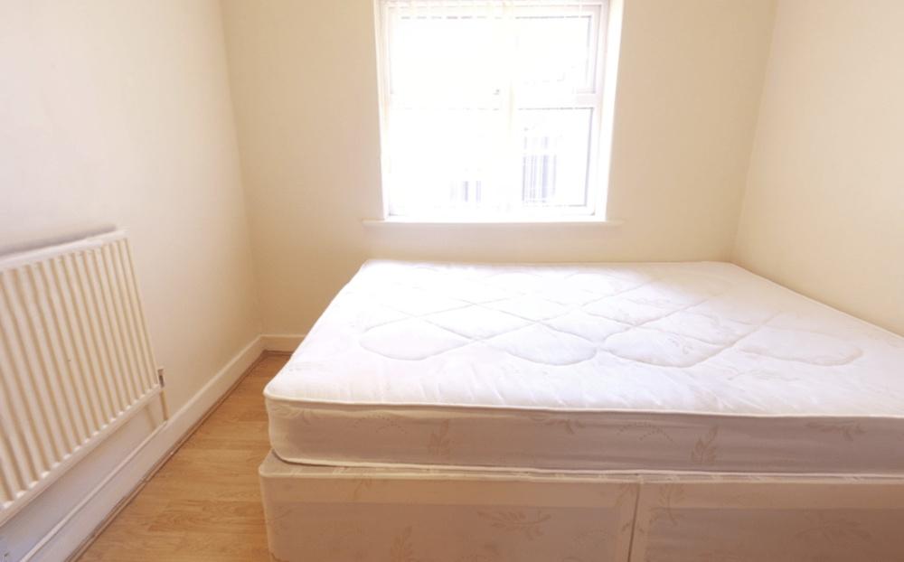 Bright, simply furnished bedroom with a double ...