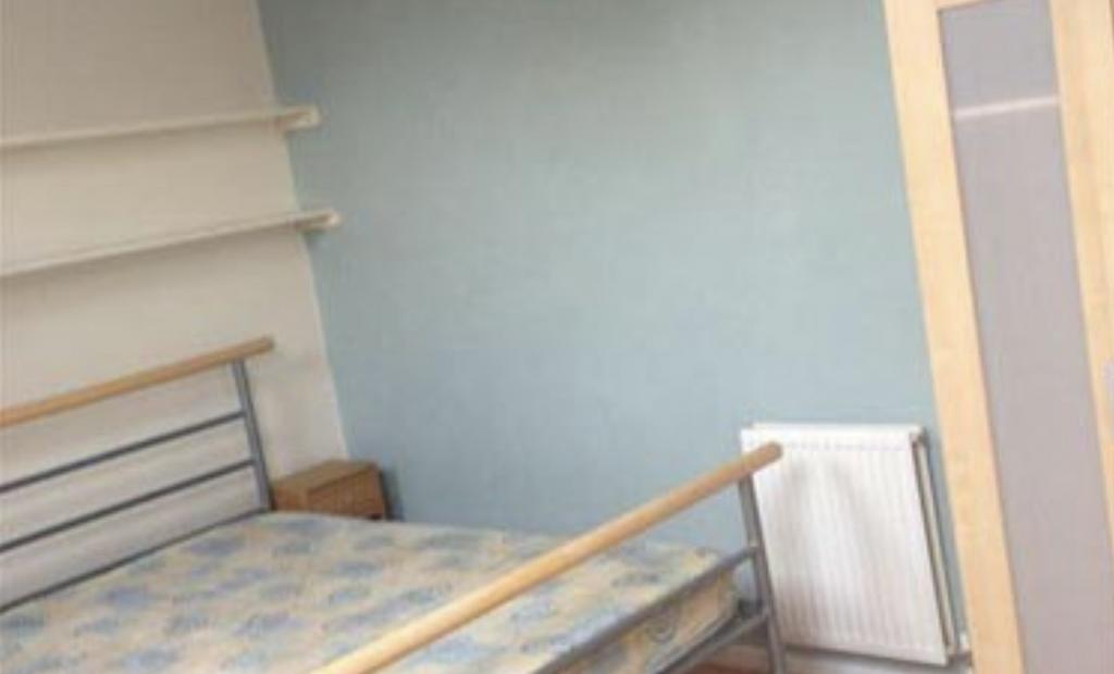 Simple furnished bedroom with a metal-framed be...