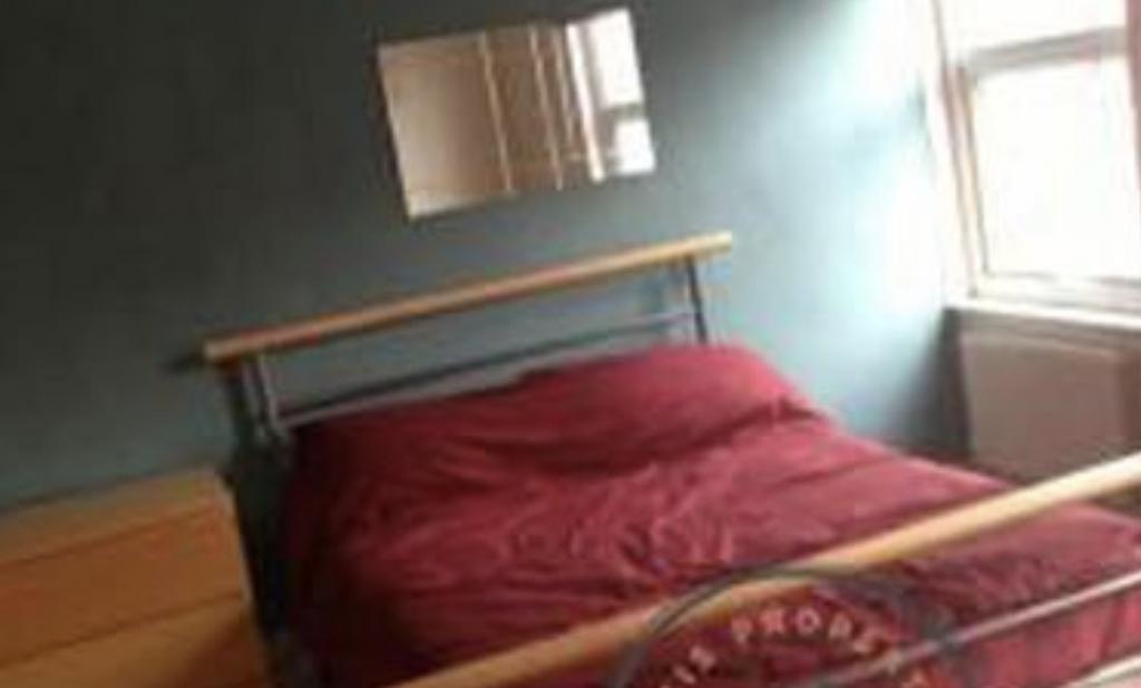 Bright double bedroom with a metal-frame double...