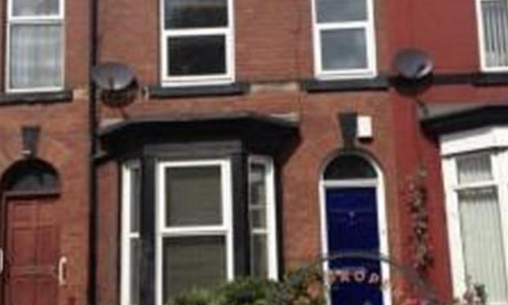 Red-brick terraced house with bay window and a ...