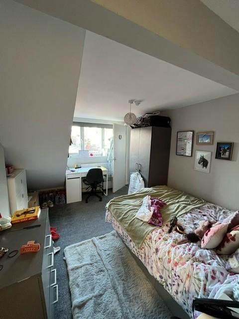 Bright, cozy bedroom with a double bed, desk by...