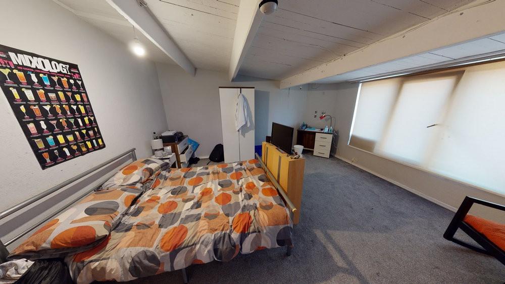 Bright, carpeted double bedroom with a patterne...