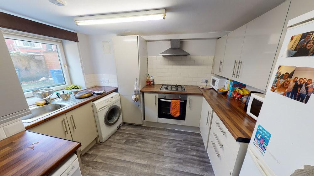 Bright, modern kitchen with white cabinets, woo...