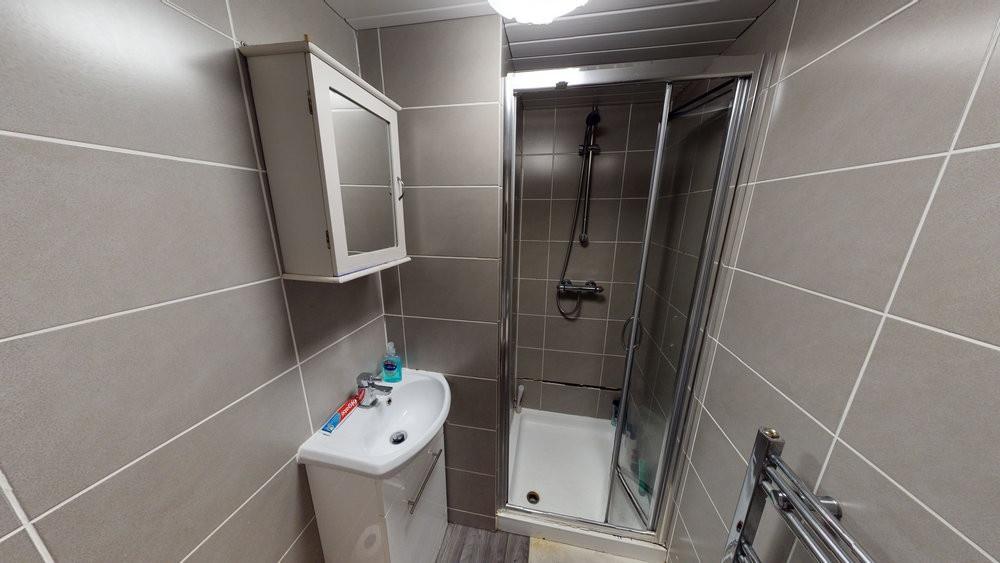 Modern tiled bathroom with a compact shower enc...