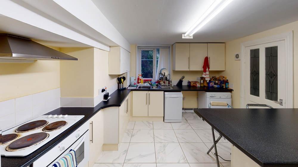 Well-equipped communal kitchen with multiple wo...