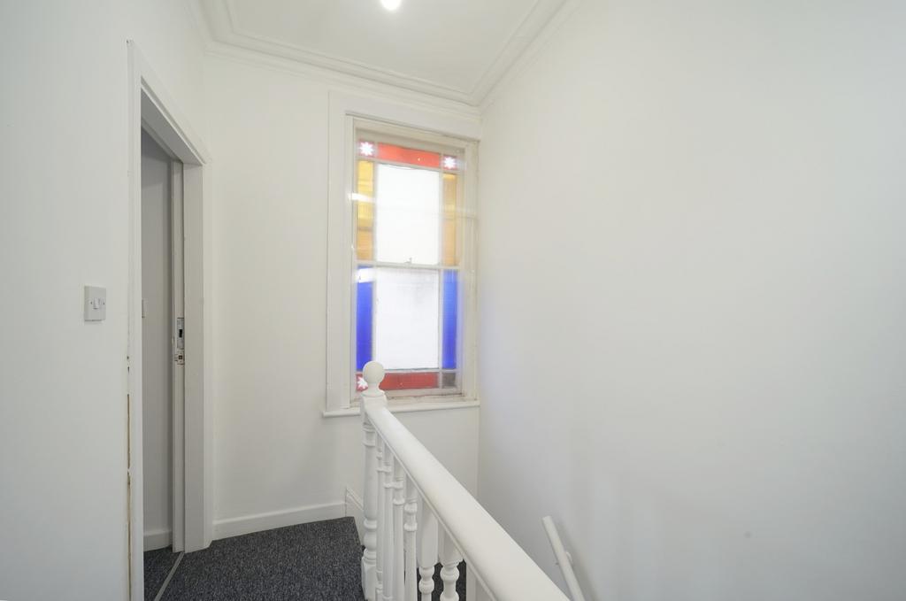 Bright upper landing with white walls, decorati...
