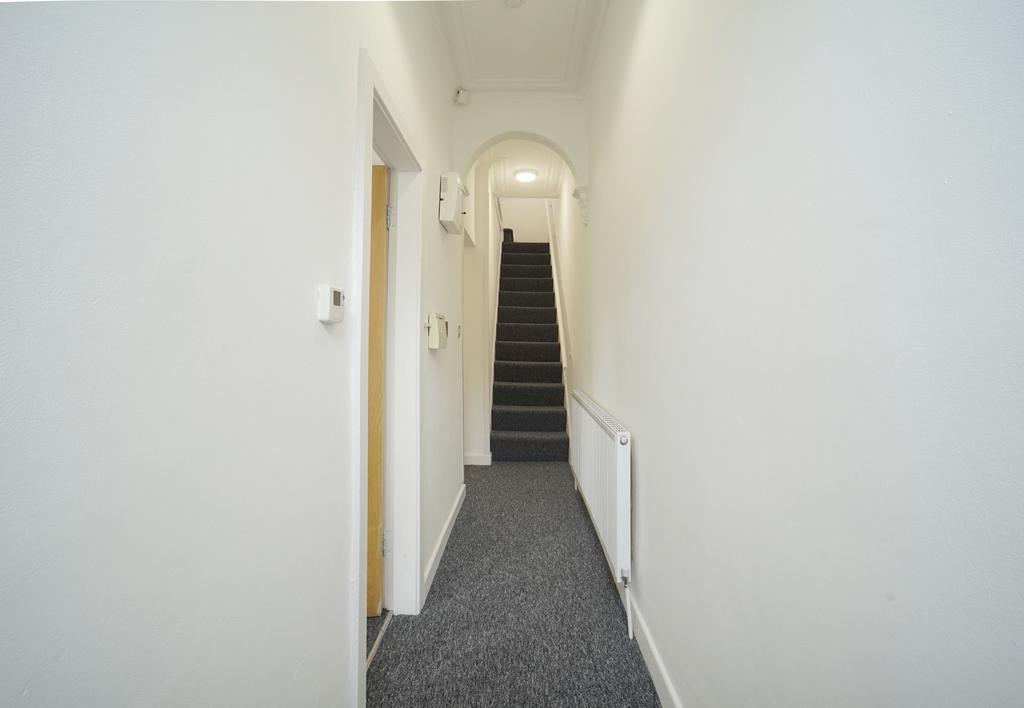 Bright, neutral hallway with clean carpeting, w...