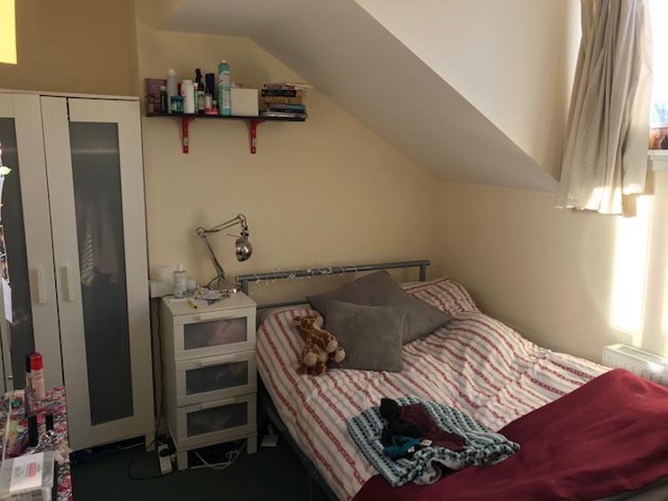 Cosy attic bedroom with a sloped ceiling, fitte...
