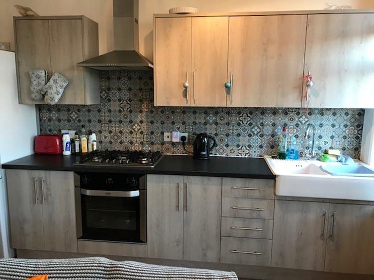 Contemporary kitchen with patterned tiled splas...