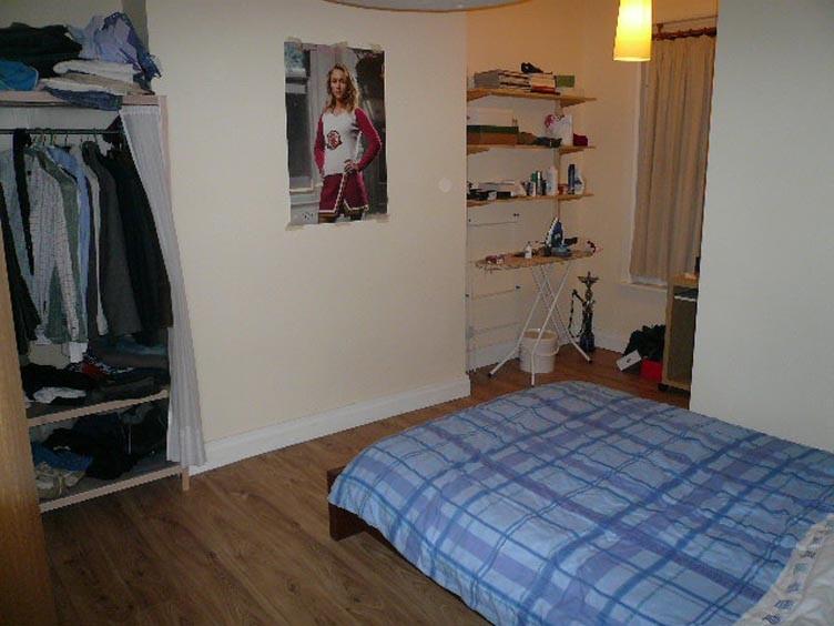 Cozy bedroom with wooden flooring, shelving for...