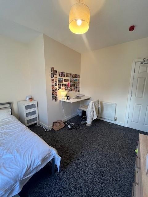 Bright, simply furnished bedroom with a single ...