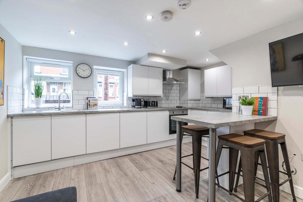 Bright, modern kitchen with sleek white cabinet...