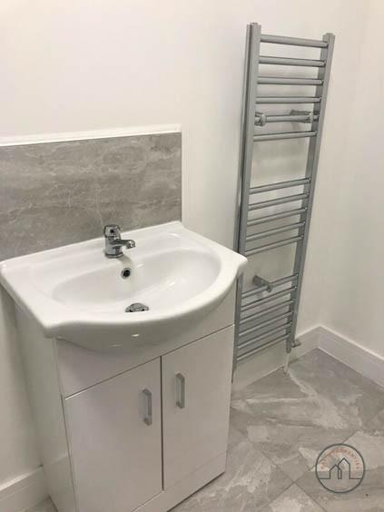 Clean, modern bathroom with a white vanity sink...