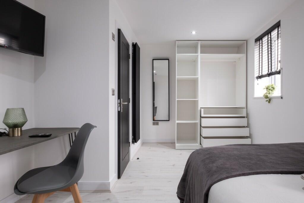 Bright and modern master bedroom featuring a co...