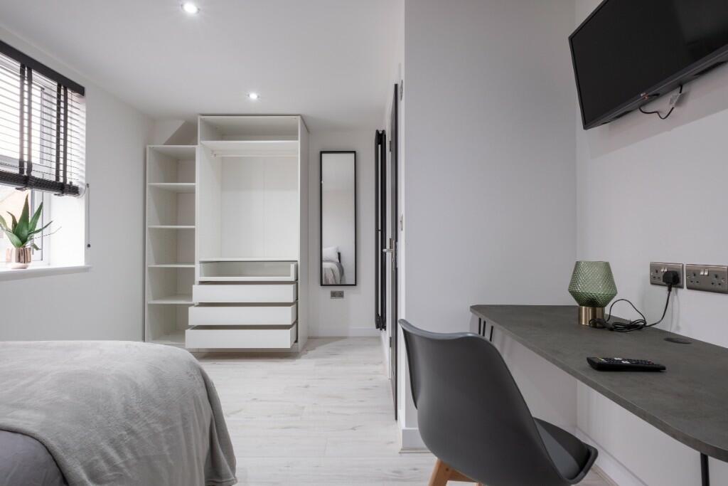 Bright and modern master bedroom featuring a co...