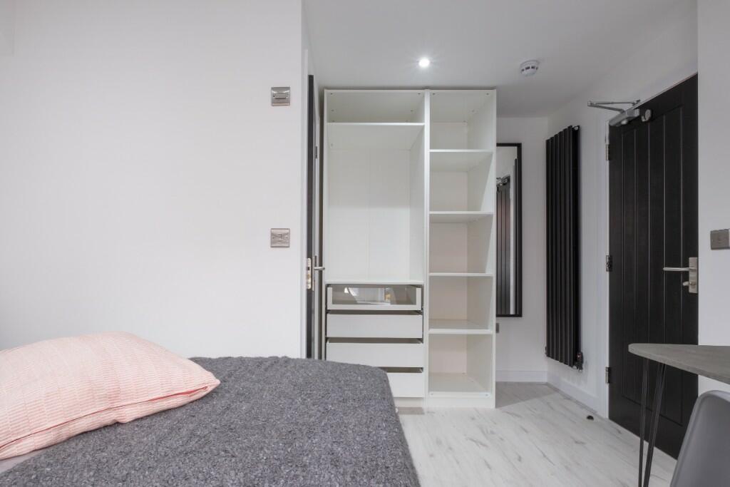 A neat and modern single bedroom featuring a co...