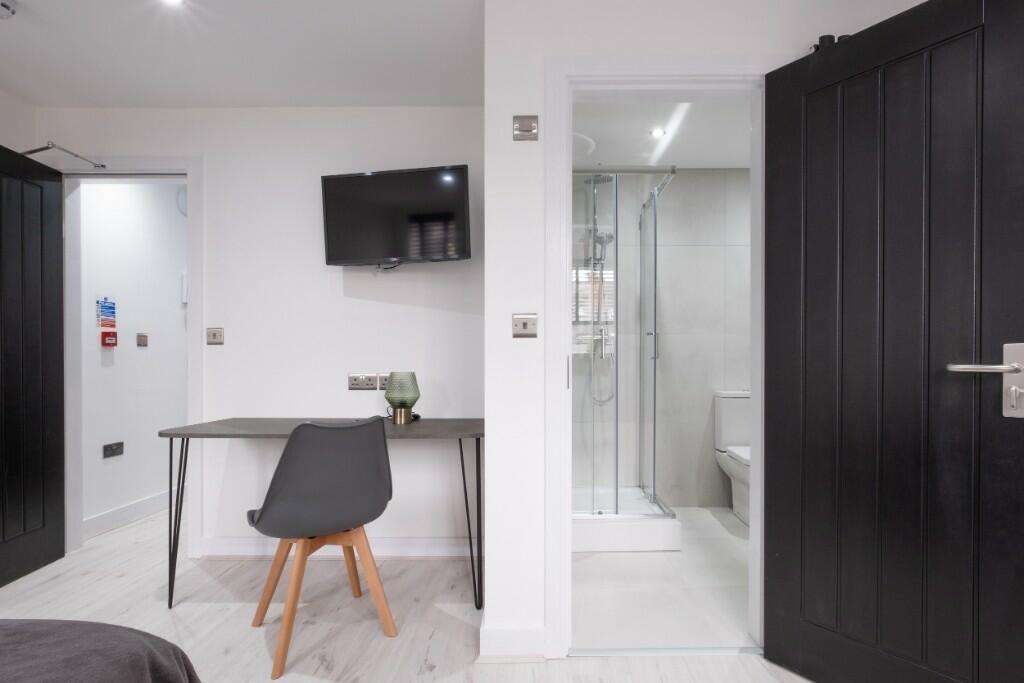 Modern double bedroom featuring a sleek desk an...