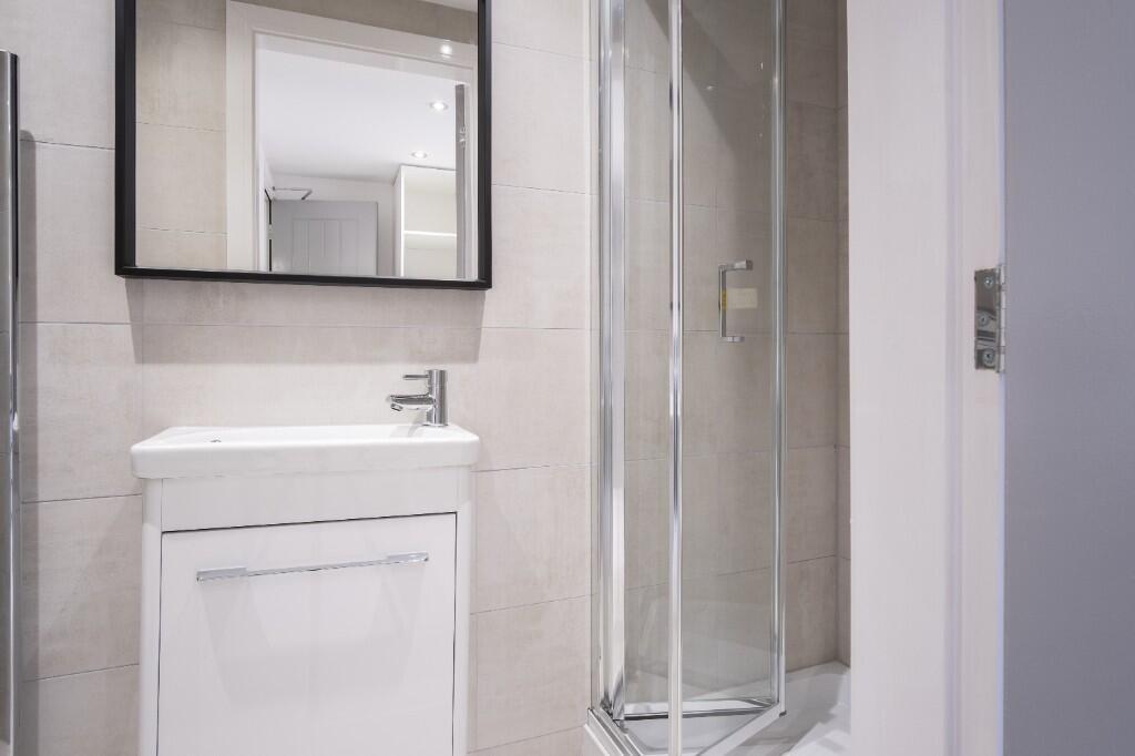 A clean and modern bathroom with a glass shower...