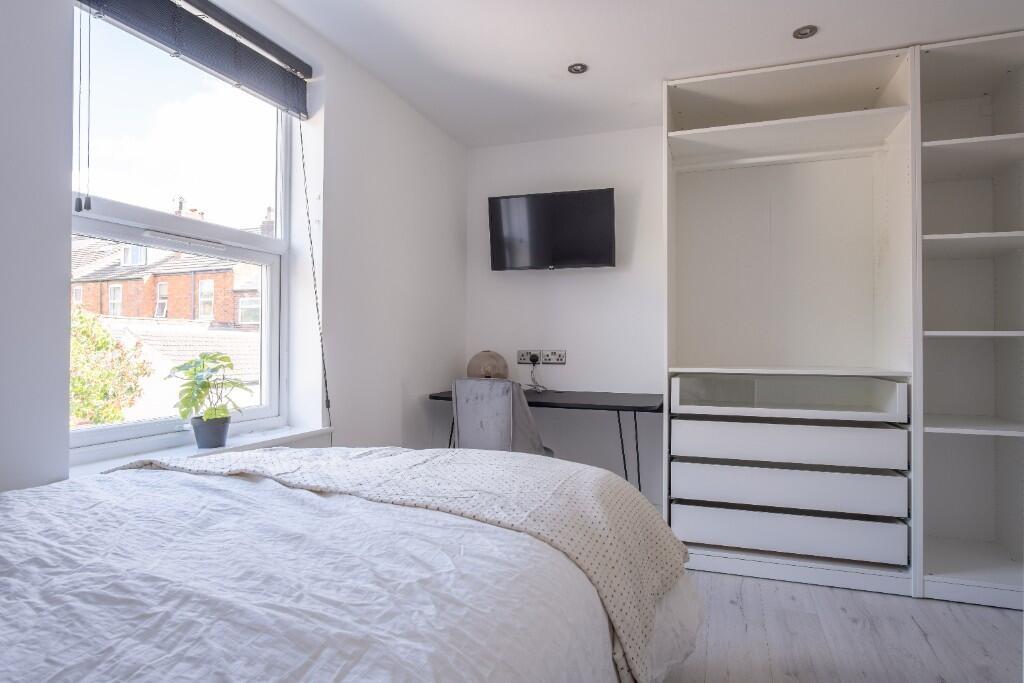 A bright and clean bedroom featuring a large wi...