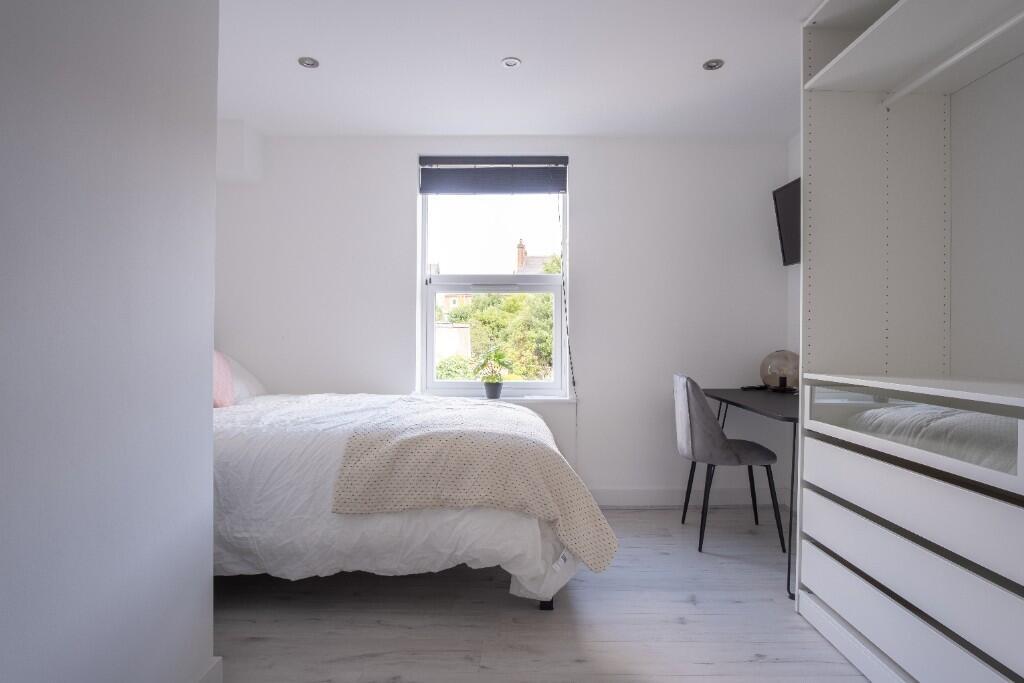 A bright and modern bedroom featuring a comfort...