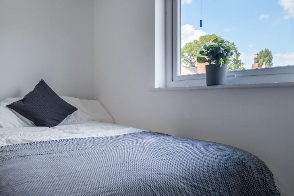A bright and inviting double bedroom with a nea...