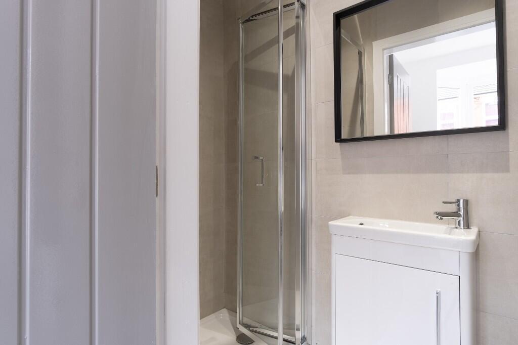 A modern bathroom featuring a glass shower encl...