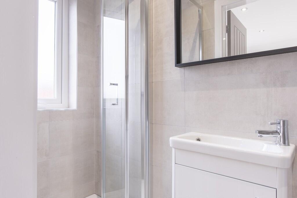 A clean, modern bathroom featuring a shower uni...
