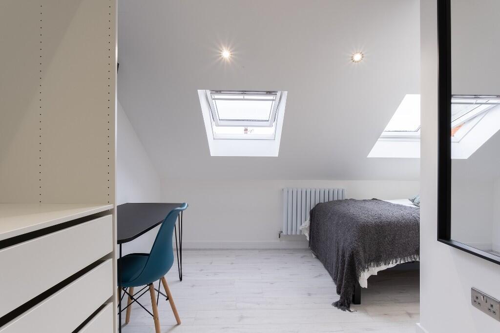A bright, modern bedroom featuring a comfortabl...