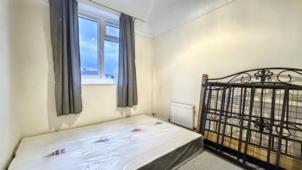 Bright, simply furnished bedroom with a double ...