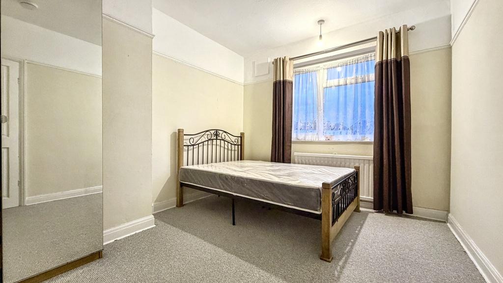 Bright, neatly presented bedroom with a metal b...