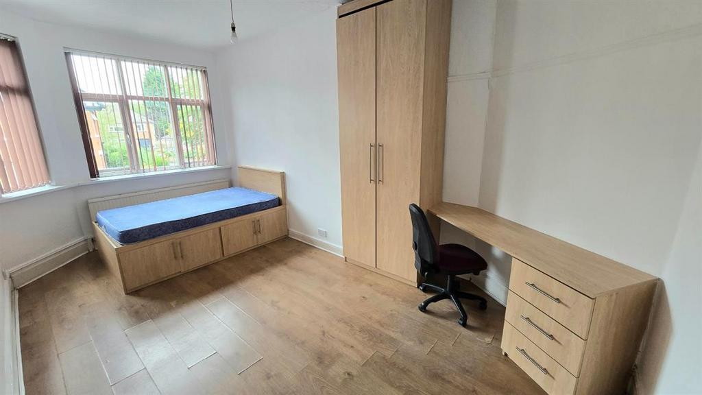 Bright furnished bedroom with a raised bed feat...