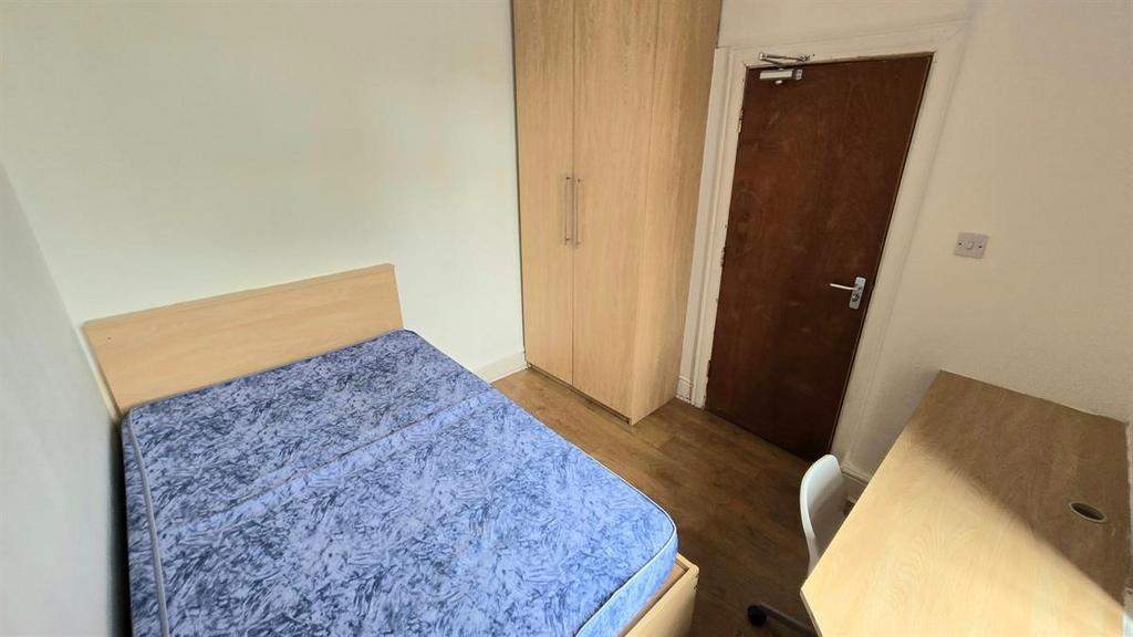 Bright, simply furnished bedroom with a double ...