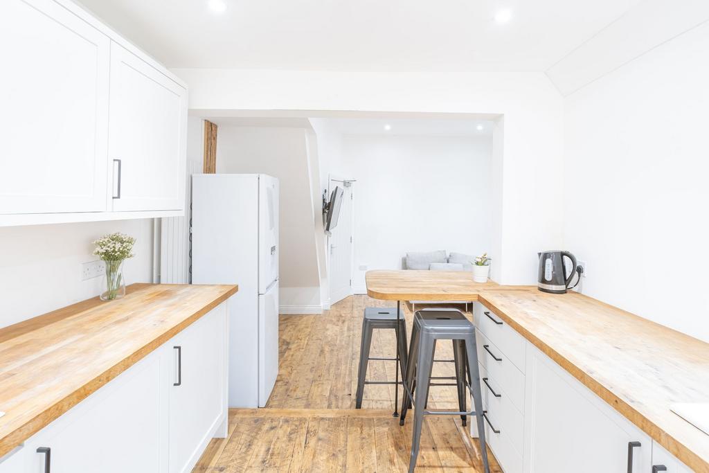 Bright and modern kitchen with white cabinetry ...