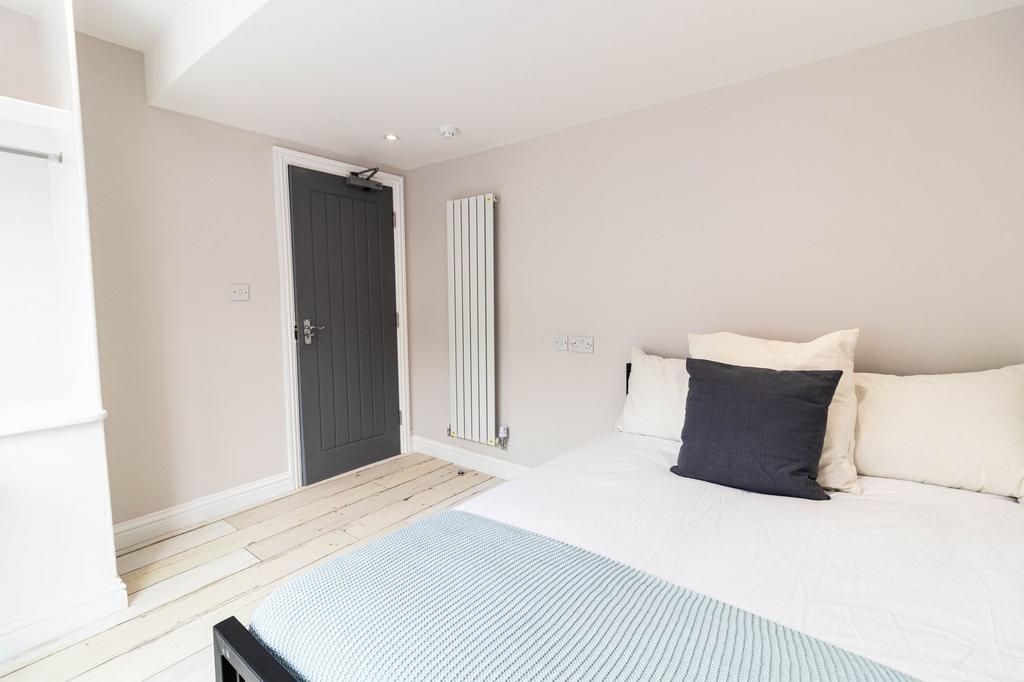 Bright and tidy bedroom featuring a comfortable...