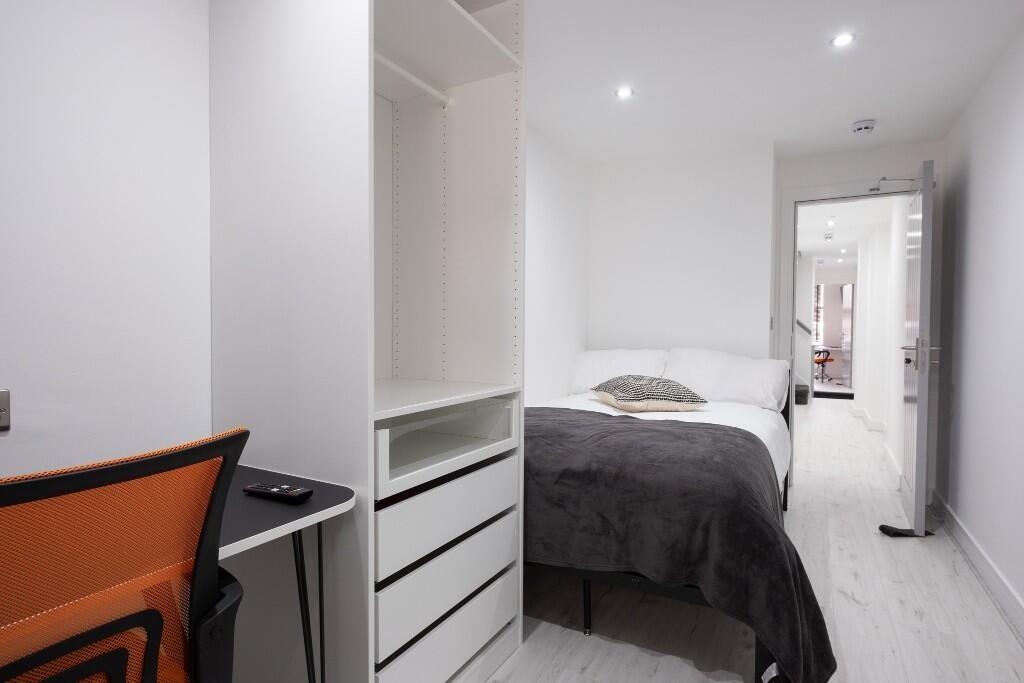 A modern and tidy bedroom featuring a comfortab...