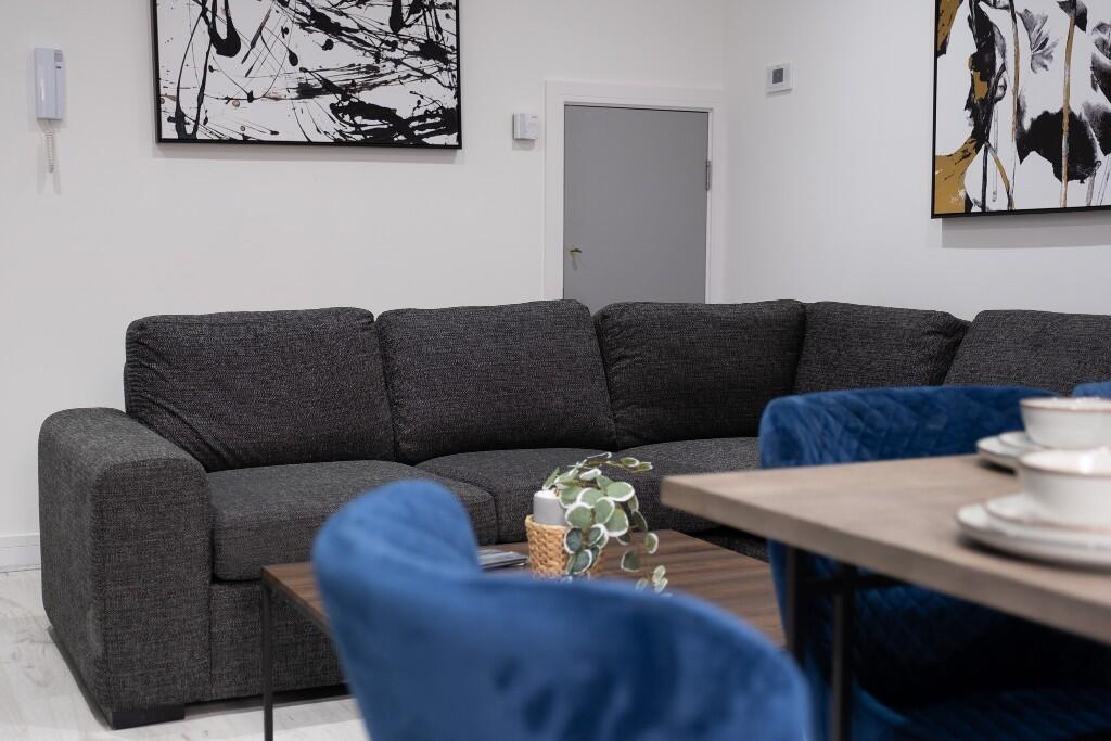 A modern living room featuring a large dark gra...