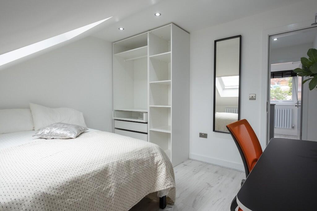 A bright and inviting bedroom featuring a comfo...