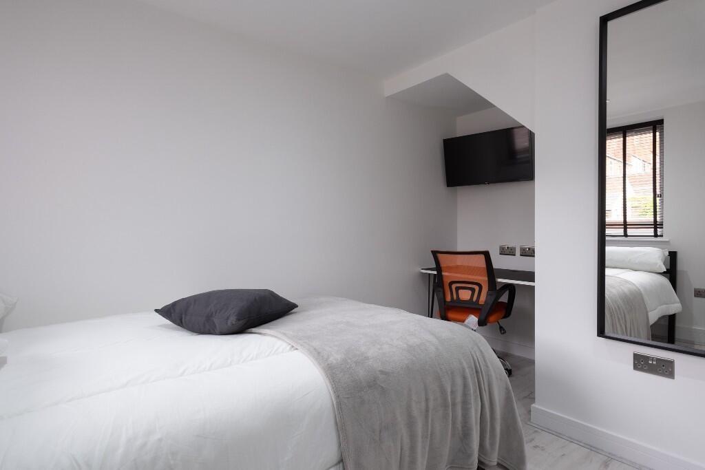 A spacious and bright master bedroom featuring ...