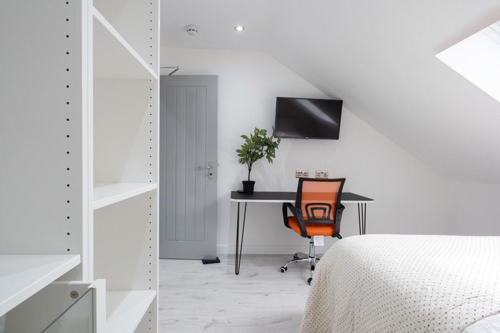 A bright and tidy bedroom featuring minimalist ...