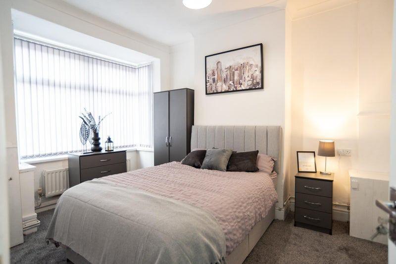 Bright, neatly styled double bedroom with a com...