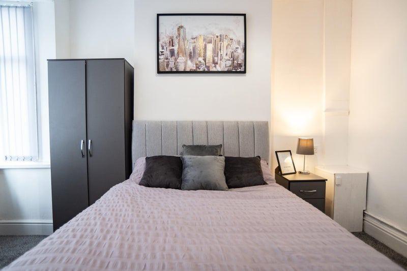 Bright, neatly styled bedroom featuring a doubl...